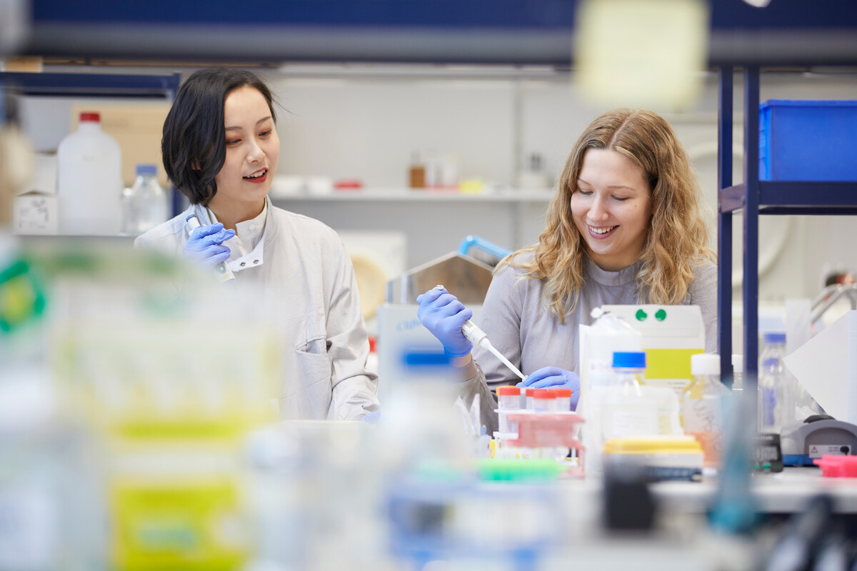 Two students in a lab, holding scientific equipment